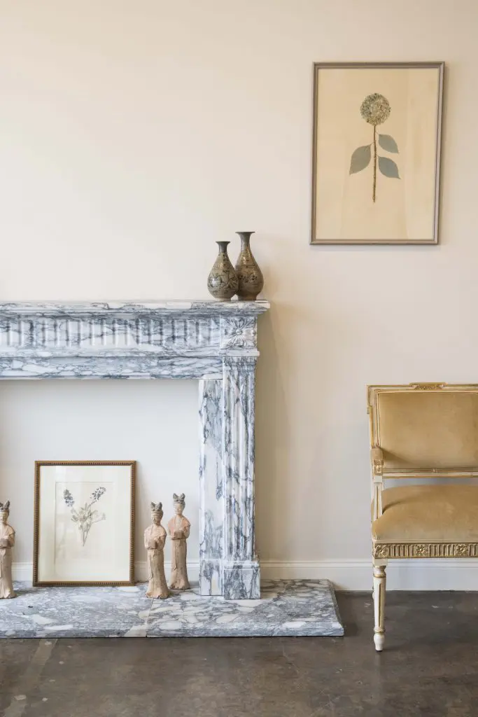 Louis XVI-style marble fireplace. Wolf Hall Atelier chair. Lauren Lachance botanicals.