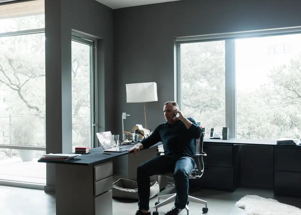The author retrofitted filing cabinets with custom-made desktops enveloped in black-billiard felt to create an expansive, functional workstation. Herman Miller filing cabinets and Setu Chair. Model BB3/X3 floor lamp by Noguchi.