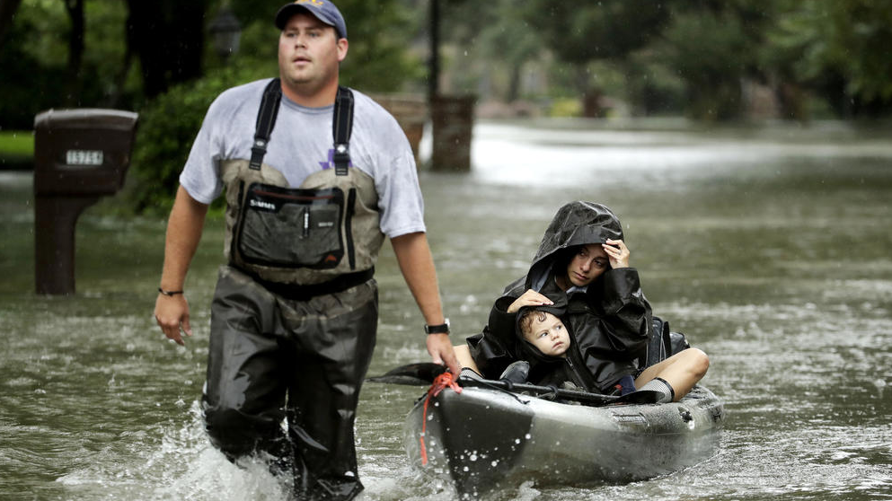 Volunteer helps rescue residents from West Houston neighborhood. (Photo by Charlie Riedel / AP) 