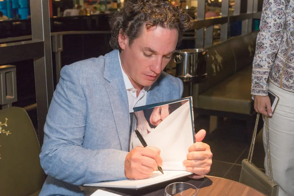 The artist inscribes his catalog.