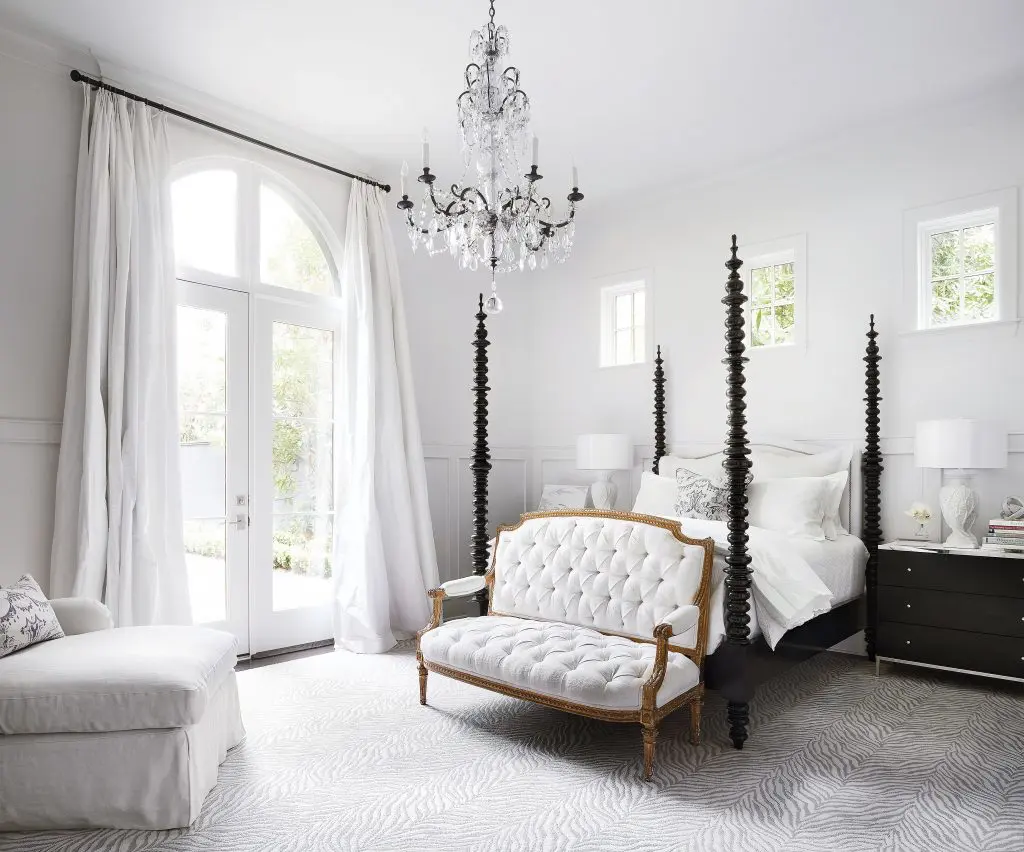 Four poster bed and gleaming chandelier are standouts in this bedroom.