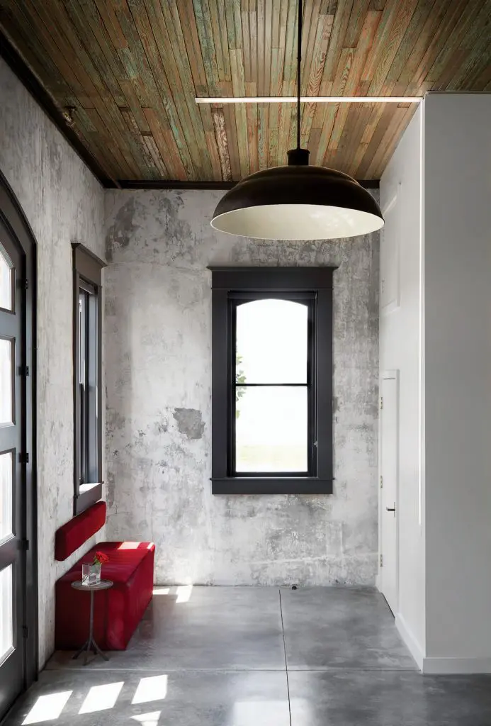 In the entry, original headboard ceilings and patinated plaster walls. Vintage light pendant, circa 1910. Custom bench. 