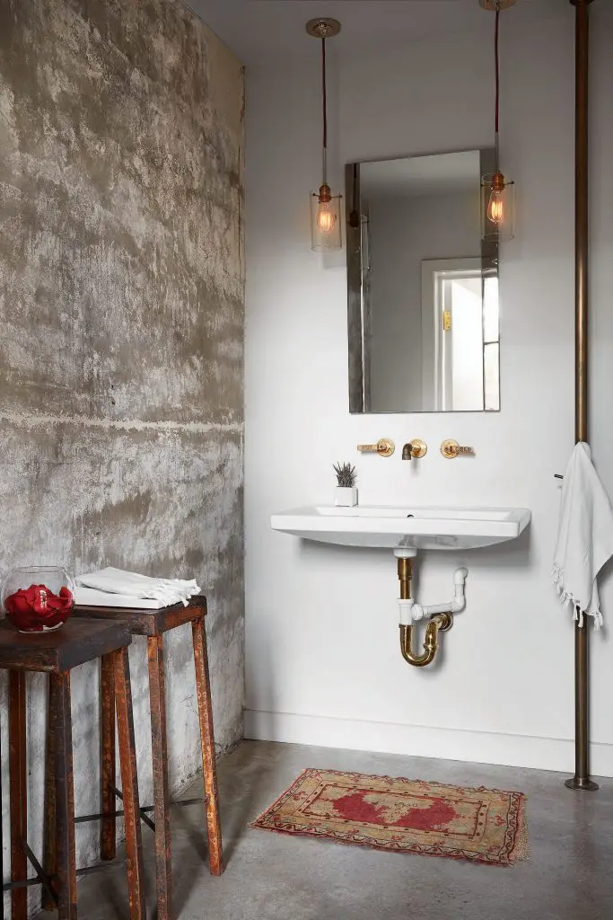The powder bath's light fixtures hang from red ropes. Brass fire pole made by James Dawson used as towel holder. Antique stools. 