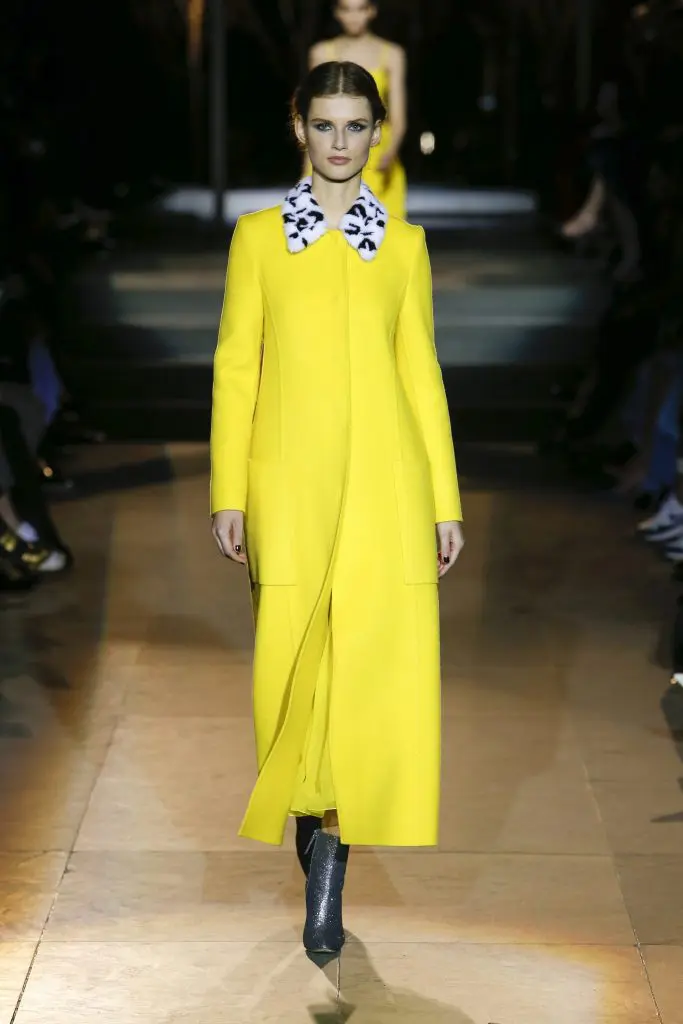 Carolina Herrera long yellow coat with black and white fur collar.