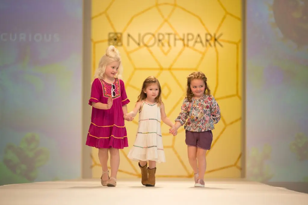 Kids take the runway during the fashion show. 