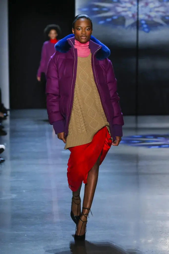 Prabal Gurung pitaya cashmere quilted puffer jacket with midnight Saga fur collar, peony cashmere turtleneck, camel cashmere cable knit crewneck sweater, scarlet silk crepe back satin skirt with silk chiffon draped sarong. 