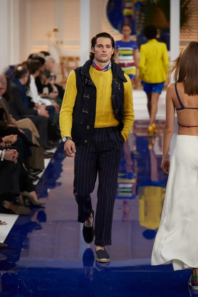 Ralph Lauren navy cotton and nylon vest,yellow cashmere cable sweater, navy and white linen pinstripe pant, red, yellow, blue and white silk scarf, navy canvas espadrille.
