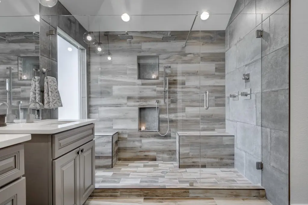 A window wall, brushed nickel accents and wood looking tiles, all in your master shower; what else can you ask for?