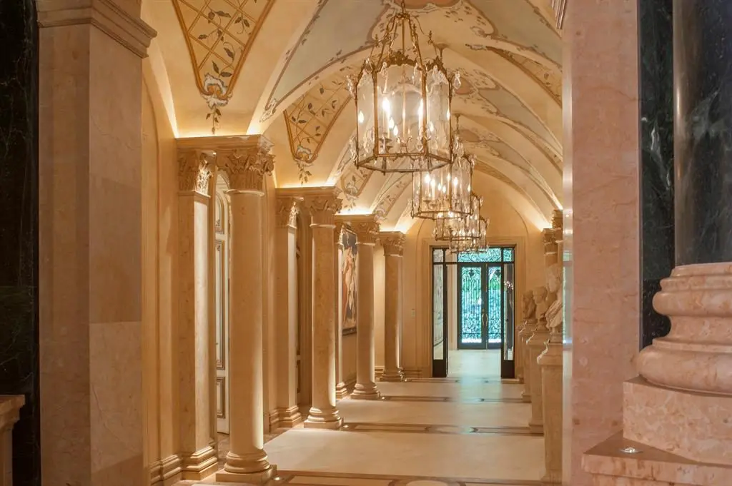 Chandeliers and marble columns line this long hallway at Chateau Cornarvon. 
