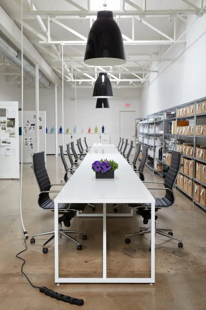 The main office area includes a Blu Dot table, Caravaggio lighting, and chairs from Wayfair.