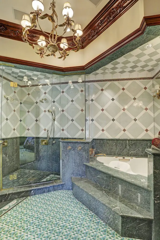 A masterful shower and tub with intricate tile work.