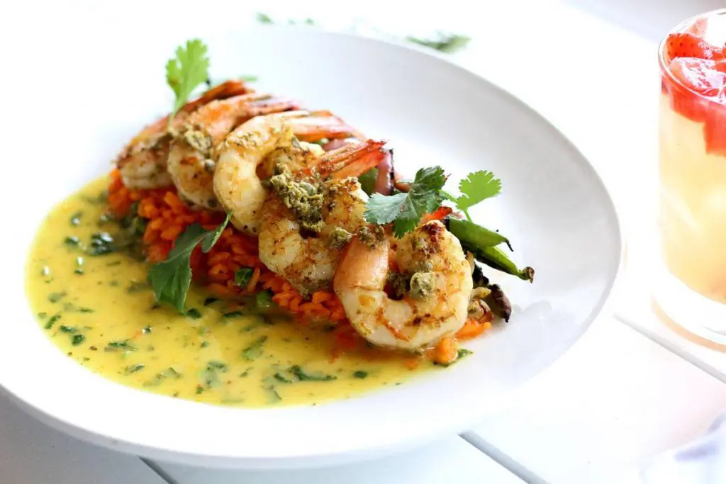 Alcomar takes seafood to the Mexican coast with dishes like this pan-seared shrimp with guajillo rice and sour orange-habanero vinaigrette. (Photo by Alcomar.)