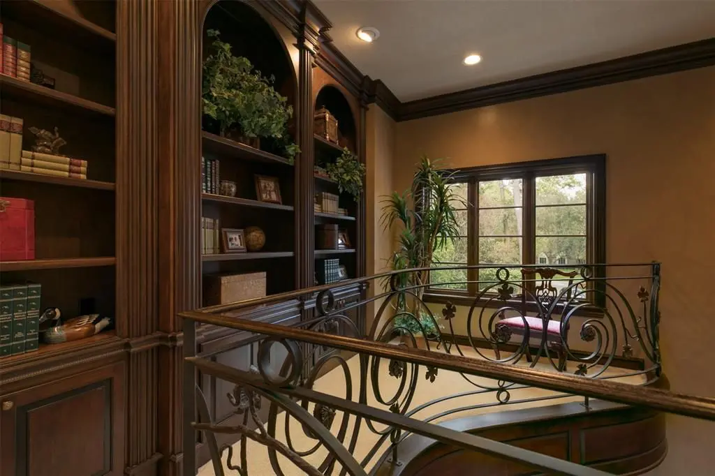 The upper study shares many elements with the lower study and has its own flair, with a wrought iron hand rail. 