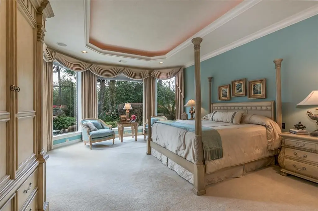 Three picture windows in the master bedroom give a peaceful view of the pool and back yard. 