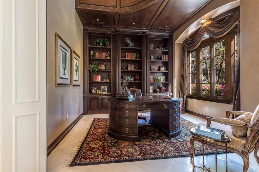 The first floor study features stained wood built-in bookcases with cabinets and adjustable shelves. 