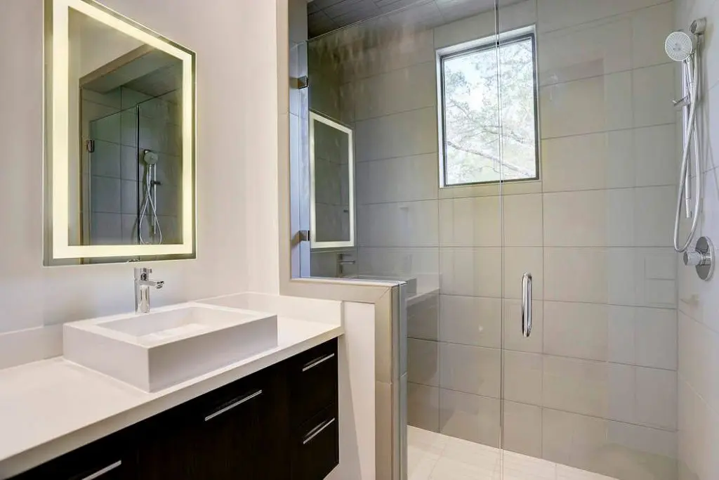 This en suite bathroom features an oversized glass and porcelain shower. 