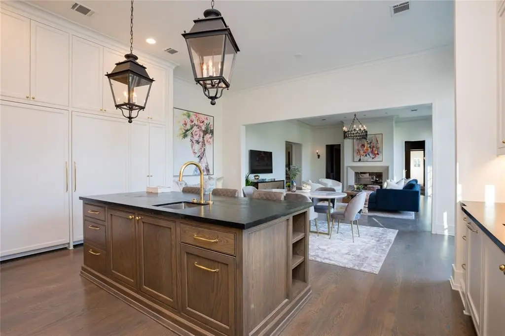 Dual antique nickel and copper sconces and a pair of iron lanterns hang over the island. 