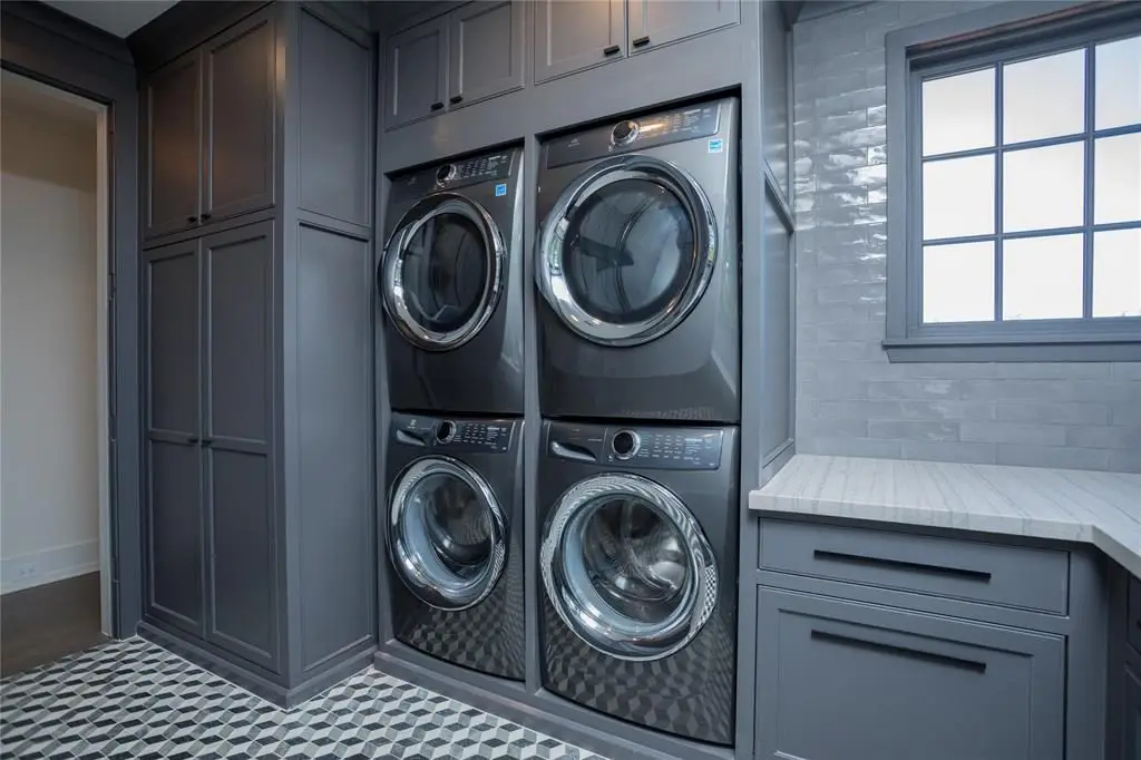 The quartz mosaic floor and Opus white quartzite counter make for an elegant laundry room. 