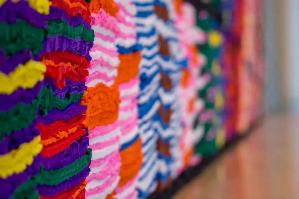 Three black stripes of crêpe paper run through the length of the wall – one along the top, one through the middle, and one at the bottom to give the wall some perceived structure. 
