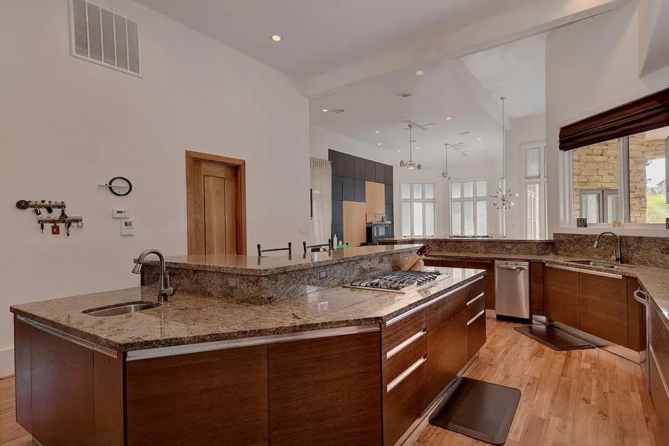 The granite-top island is equipped with its own sink, outlets and stove top. 