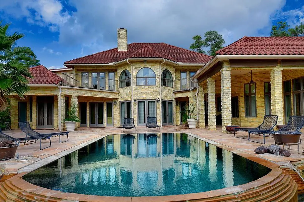 The sparkling pool sits in the lush backyard. 