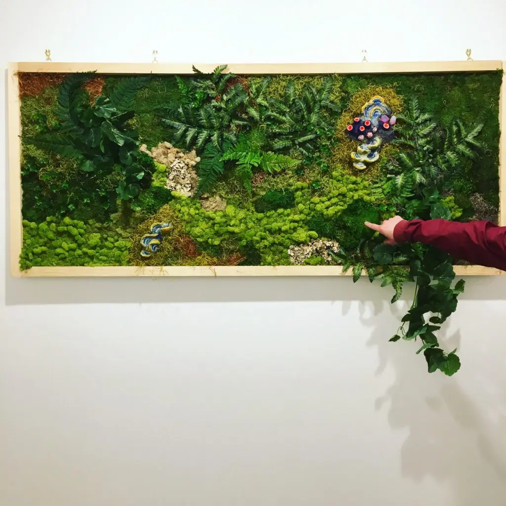 The artist collects plant specimens to include in her work.