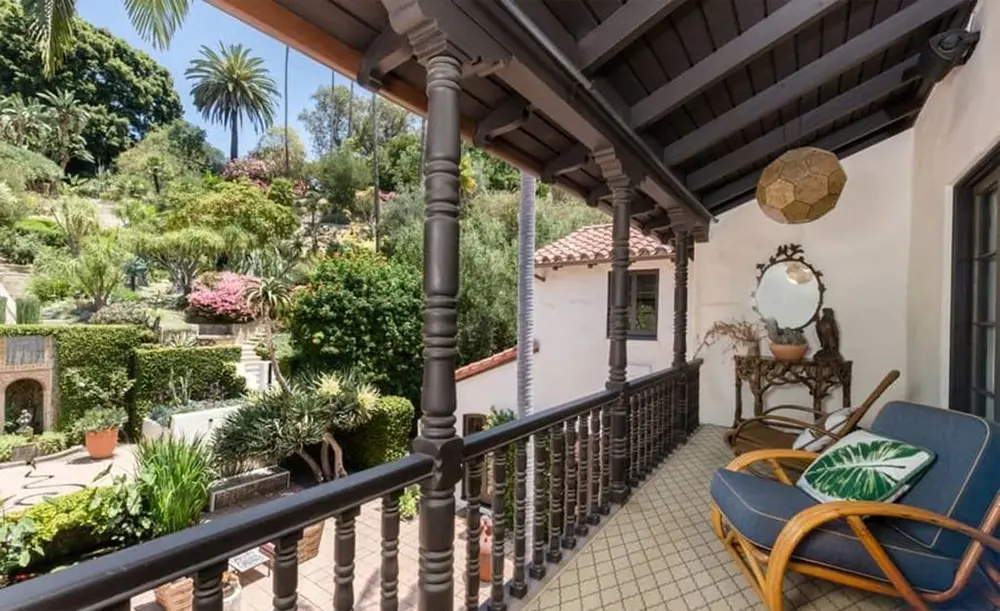 The mansion features several balconies and terraces overlooking the lush landscaping. 