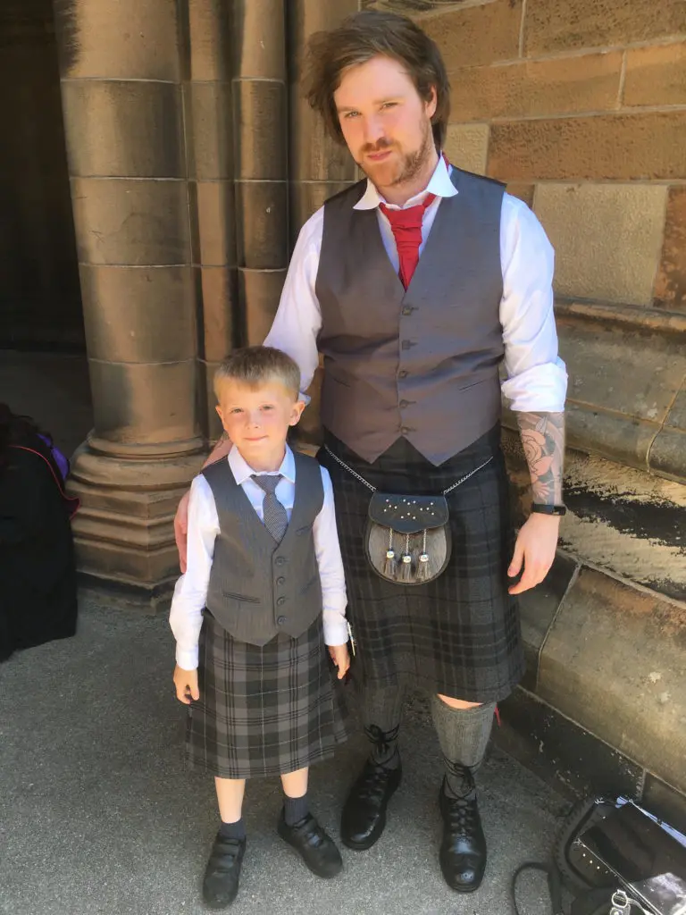 A man and his son share a moment at the University of Glasgow graduation commencement ceremony.