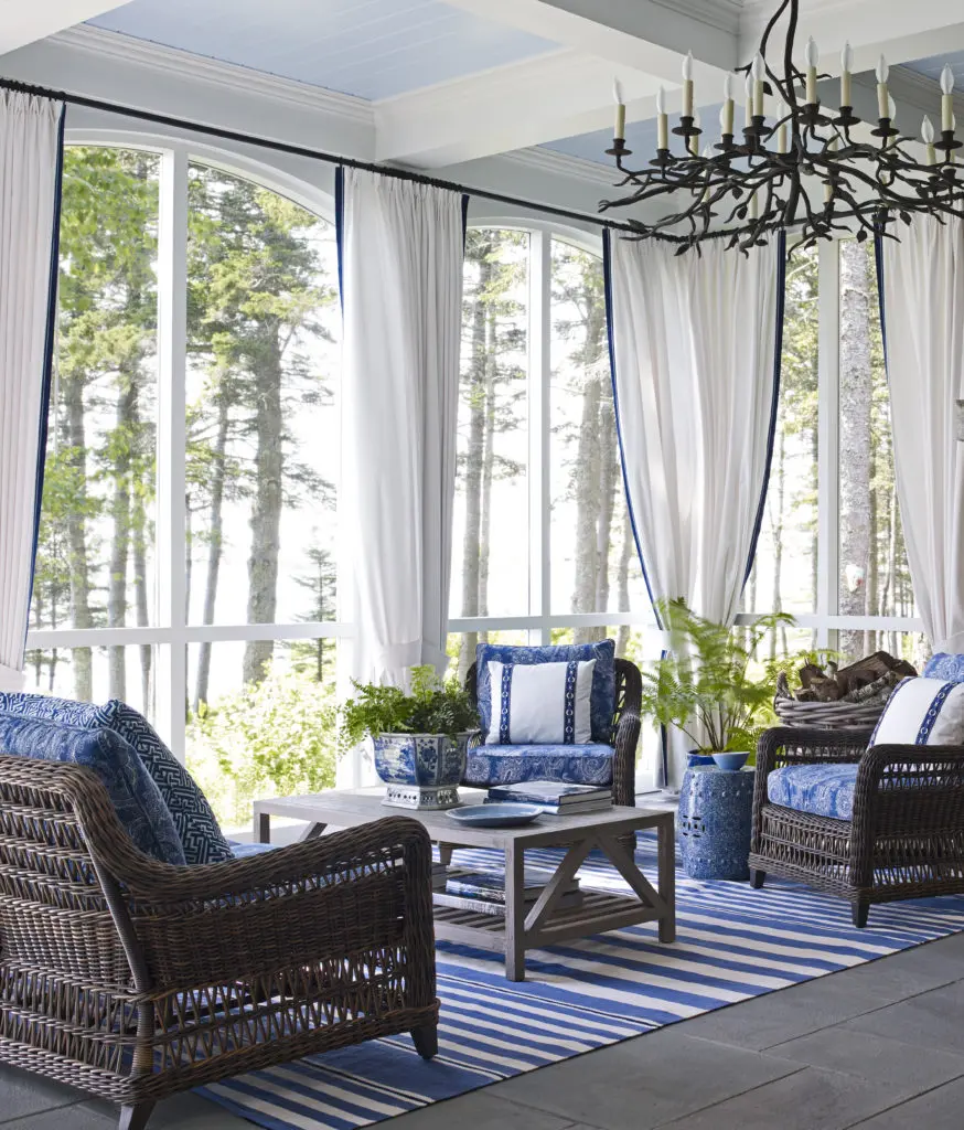 The enclosed porch is attached to the main house. Linen curtains give the exterior room the feeling of an interior room. A project from Suzanne Kasler: Sophisticated Simplicity. Photo by William Waldron.