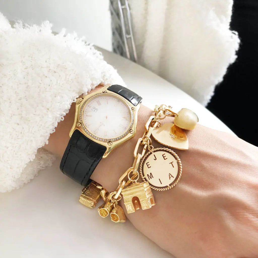 A charm bracelet layered with a watch makes for a timeless look