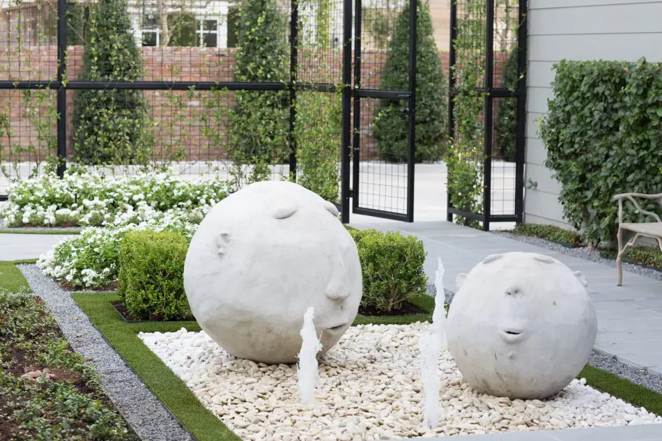 The client's stone head art pieces were incorporated and repurposed into a custom fountain.