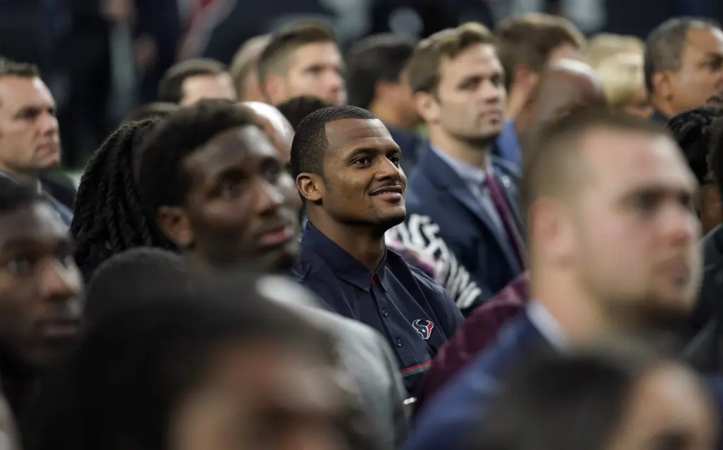 Houston Texans quarterback Deshaun Watson smiles as he watches a video tribute with teammates during a public celebration of life for Houston Texans owner Robert C. McNair at NRG Stadium. (AP Photo/David J. Phillip, POOL)