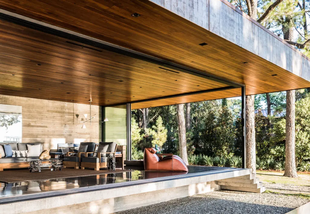 A sitting area with sliding glass walls in a Cedar Creek house by Wernerfield architects with 
a 1970s Mario Bellini leather chaise and teak chairs from David Sutherland.
 (Photo by Nikolas Koenig)