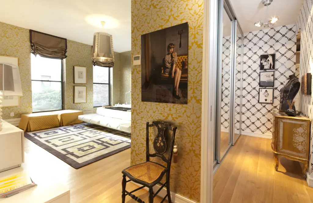 The silver and gold damask wallpaper is an elegant backdrop for the master bedroom furnishing. (Photo by Julie Soefer)