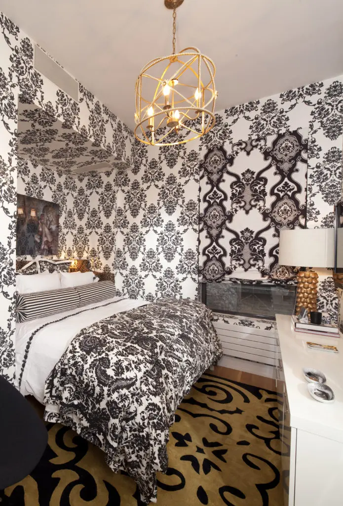 The cozy guest bedroom in the loft is a riot of black and white damask. (Photo by Julie Soefer)