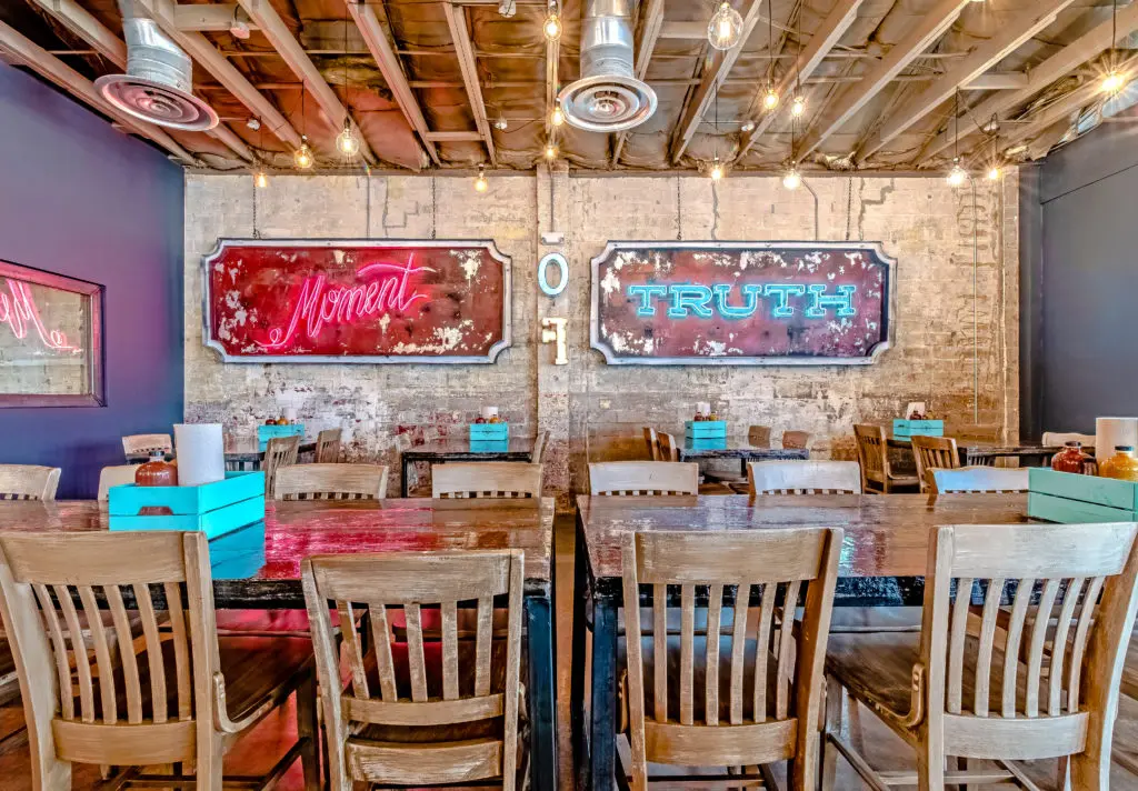 Exposed brick walls are adorned with neon light designs. (Photo by Vanessa Chavez)