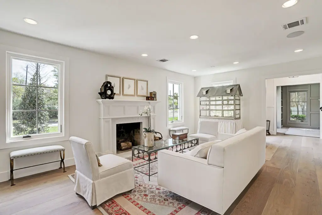 The living room with a fireplace and wide planked European floors.