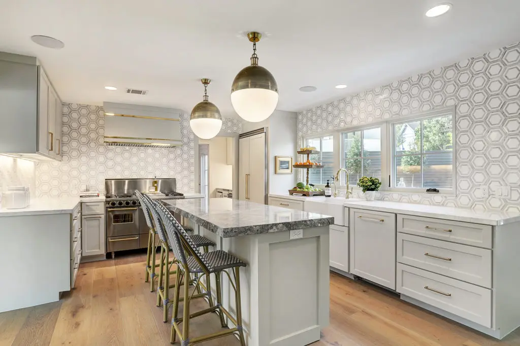 A chef's kitchen with a large island and view of the backyard.