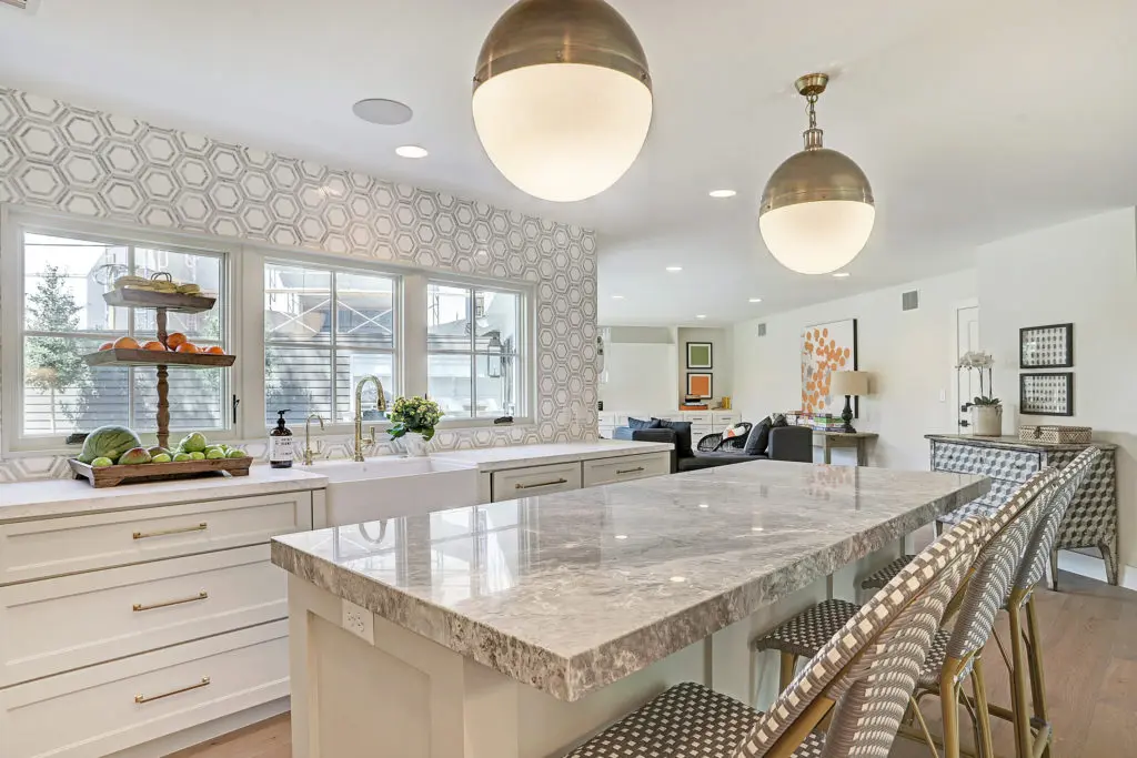 A chef's kitchen with a large island and view of the backyard.