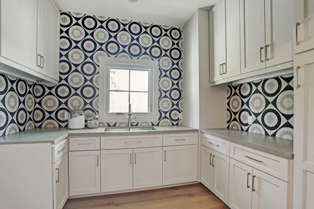 The utility room features designer tile and loads of storage.