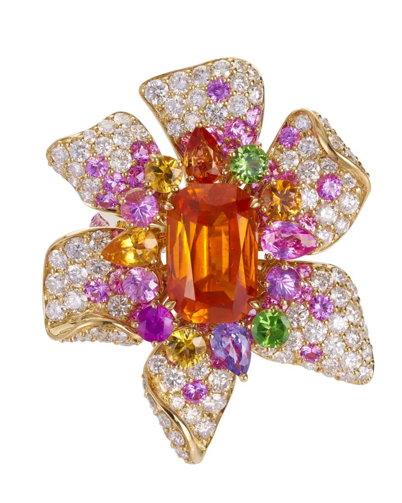 A Margot McKinney starburst ring centered with a Mandarin garnet and surrounded by gemstones and diamonds.