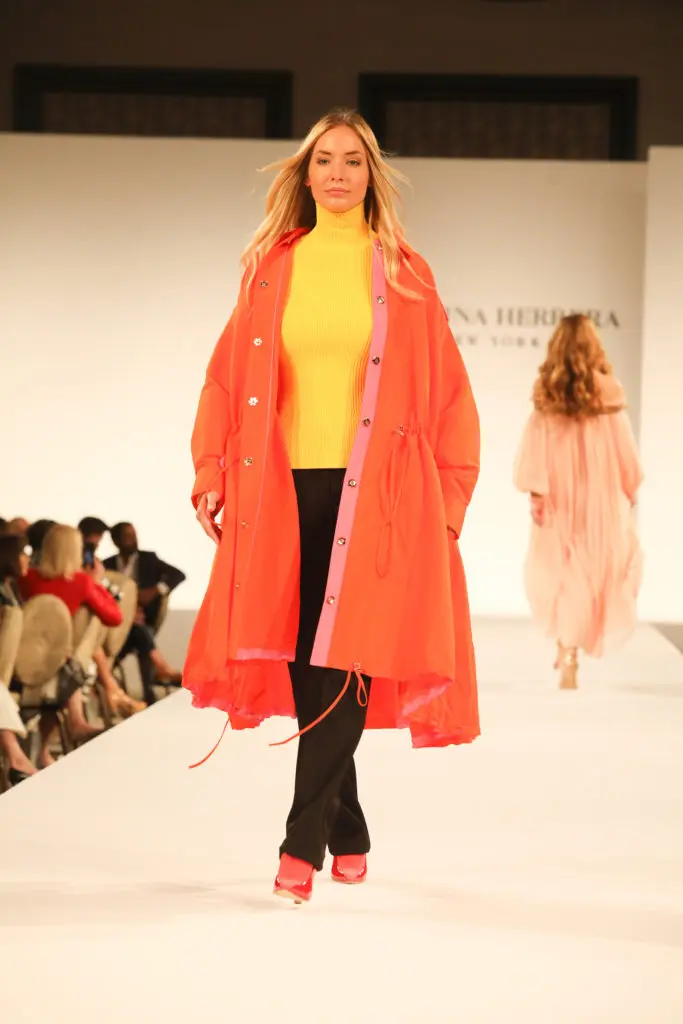 Carolina Herrera yellow turtleneck, black trousers, and orange poncho coat. (Photo by Priscilla Dickson Photography)
