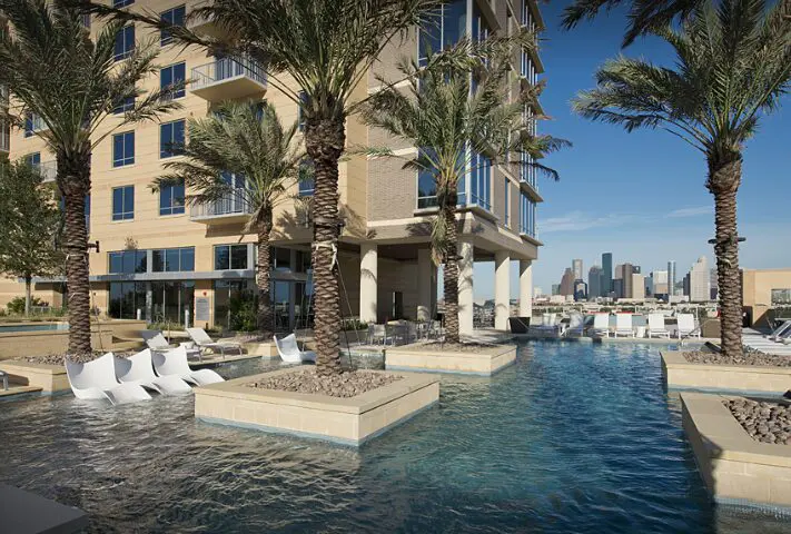This expansive pool at The Sovereign features palm trees and cozy chaises set in the shallow water. 