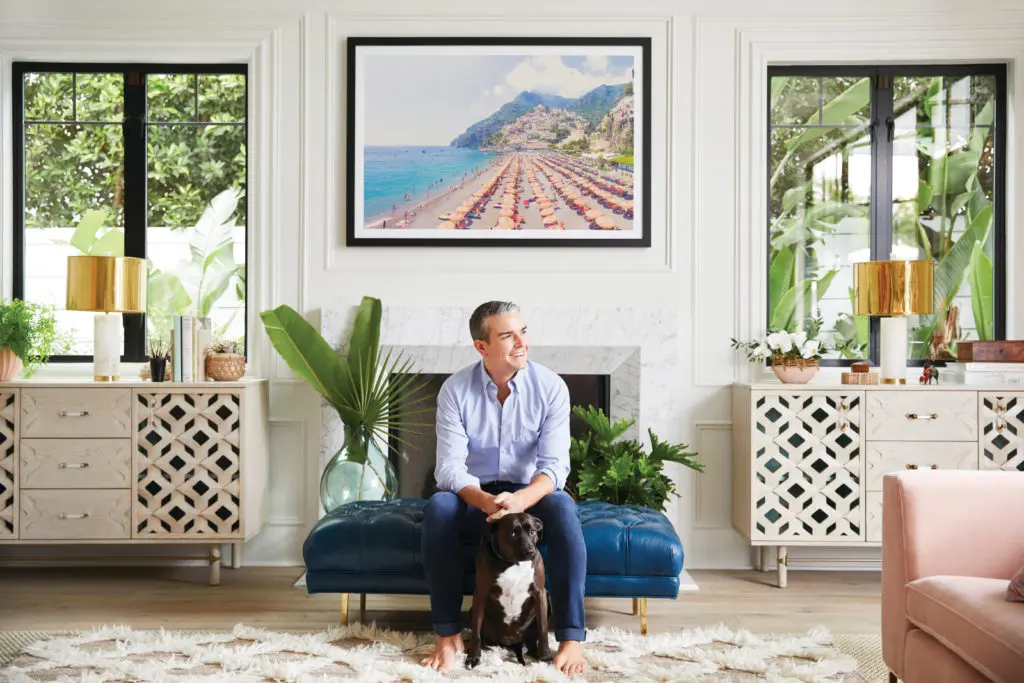Gray Malin and his dog, Stella, in front of a photograph ("Positano Beach Vista") from his Italy series.