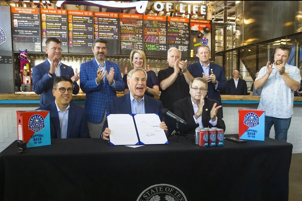 Governor Greg Abbott signs beer to go law at Austin Beerworks. (Photo by Jana Birchum)