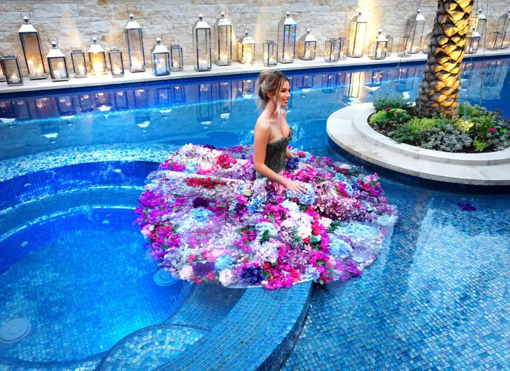 A water nymph in flower-decked gown circulated through the swimming pool at the Theorem Wine release party. (Photo by Al Torres Photography)