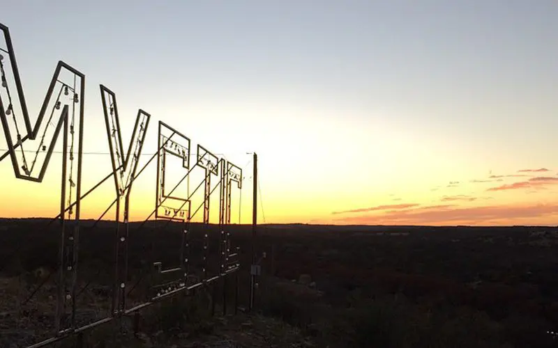 Camp Mystic's sign lights up at night for all to see.