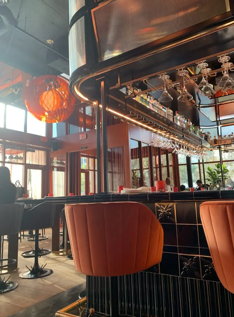 The bar is tiled and surrounded with vibrant orange chairs.  (Photo by Public Content)