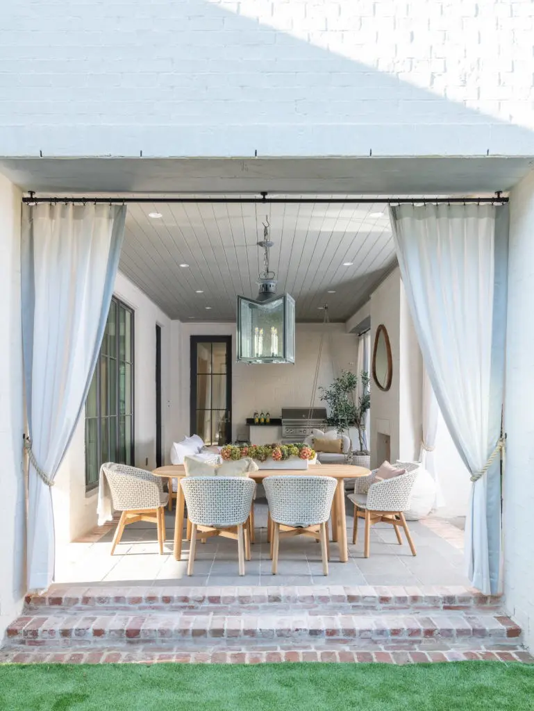 Drapery wraps the veranda in beach cabana ambience, by Roxanne Wimmel of Wimmel Design & Construction. (Photo by Michael Hunter Photography)