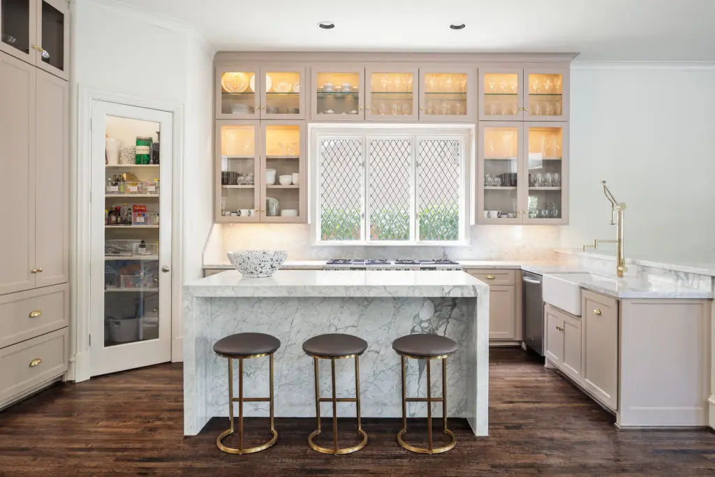 The open concept kitchen features a marble waterfall island.